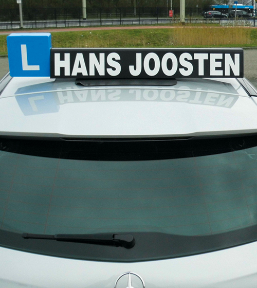 Lesauto van Verkeersschool Hans Joosten met L-bord